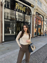 a lady wears a beige polo sweater